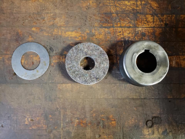Once the bearing goes in, then from left to right goes... 1. A thrust washer 2. A felt washer. 3. An original dust cover (they do not reproduce these for the early rear ends).
