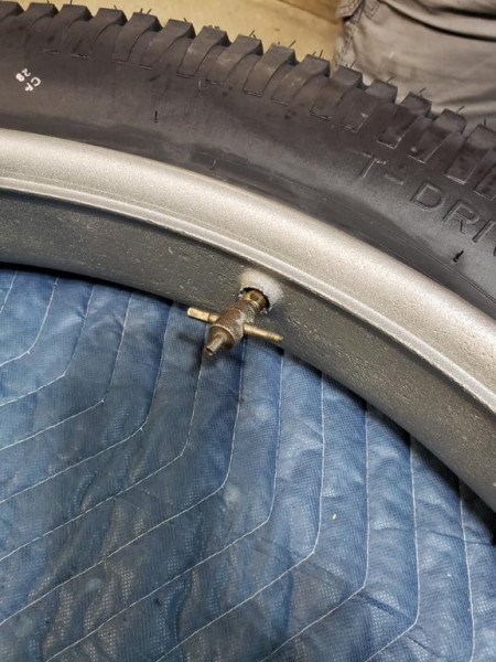 The schrader valve tool is placed on the stem temporarily to keep it in place.