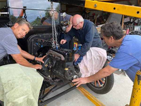 Wayne, Gene and Brian making sure the engine goes in smoothly. Ron is underneath fitting the universal into the engine