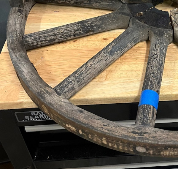 Left rear wheel showing rounded spokes and felloe.