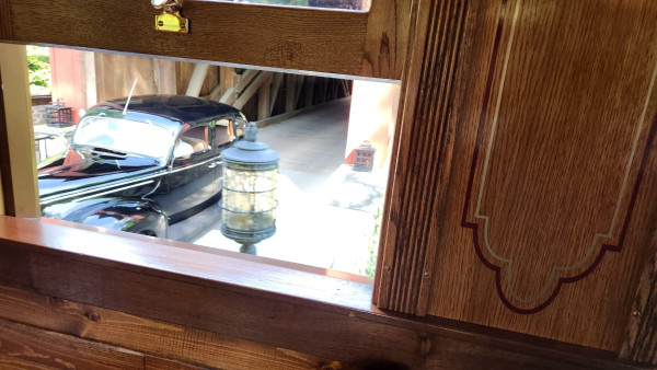 Passing the covered bridge, on the train, with a Ford waiting at the crossing!