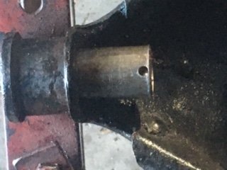 Small hole near edge of bushing.  Follow this with larger hole which breaks out the back of the bush, and file edges.