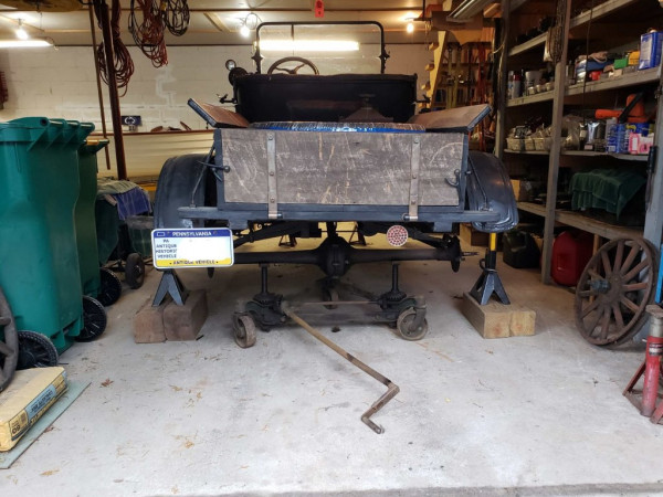 The truck frame and body is safely supported on jack stands and a digging iron made from a New Idea manure spreader axle.