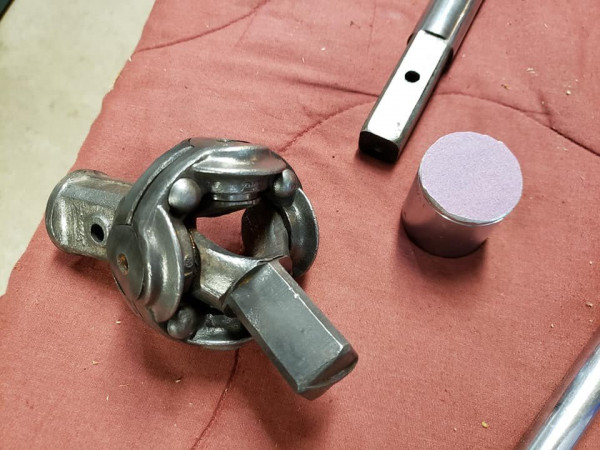 Universal joint, driveshaft end and 13/16 socket with sandpaper glued to it we used to face the brass bushing to meet tolerances..